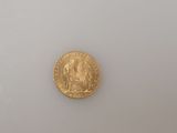 a close up of a gold coin on a white surface