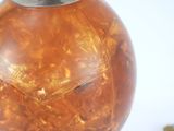 a glass vase with a metal lid on a table