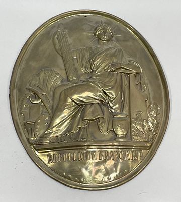 an image of a gold medal with a woman sitting on a chair