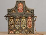 une vieille boîte en métal ornée de motifs décoratifs, posée sur une table