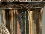 a silver vase with a lion head on the top of it