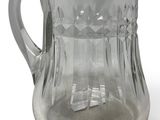 a glass pitcher with a handle on a white surface