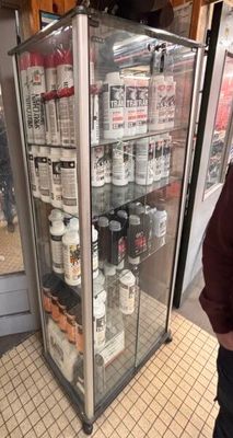 a man standing in front of a display case filled with bottles