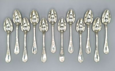 six silver spoons are lined up in a row on a gray surface