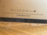 the back of a laptop computer sitting on top of a wooden table