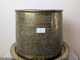a gold vase on a marble table with a label on it