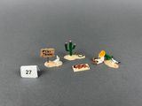 three small toy figurines of desert animals and a sign