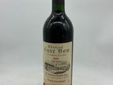 une bouteille de vin rouge avec une étiquette, posée sur une surface blanche