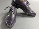 a pair of purple shoes on a gray surface