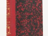 un livre rouge et noir posé sur une table blanche