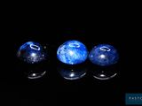 trois billes bleues posées sur une surface noire