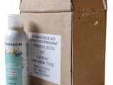 une photo d'un flacon de spray posé à côté d'une boîte en carton