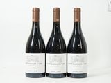 trois bouteilles de vin posées sur une table blanche