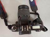 a camera strap attached to a camera with a lens attached to it