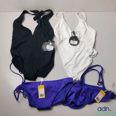 three swimsuits are laid out on a table with tags attached to them