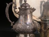 une théière en argent à côté d'un plat en argent et d'un miroir