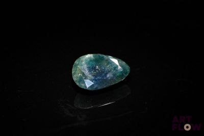a blue and green stone on a black surface