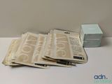 une pile de papiers posée sur une table à côté d'une boîte de mouchoirs