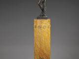 a bronze statue of a man standing on top of a marble pedestal