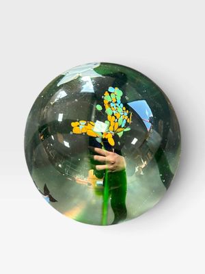 une boule de verre sur laquelle est représentée une personne tenant une fleur