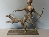 statue of a woman with a bow and a dog on a table