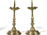 pair of antique brass candlesticks on a white background