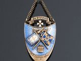 a close up of a badge on a chain on a black surface