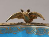 an image of a blue and gold vase with a bird on top