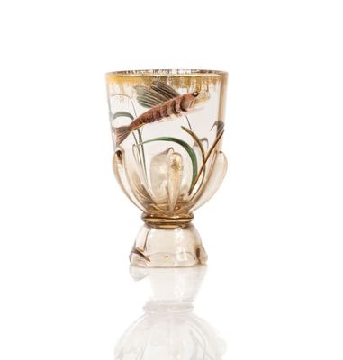 a glass cup with a fish in it on a white surface