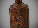une vieille bouteille en bois sur laquelle figure l'image d'un homme tenant un enfant dans ses bras