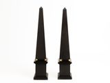 pair of black iron obelisks with gold accents on stands