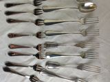 a lot of spoons and forks laid out on a table