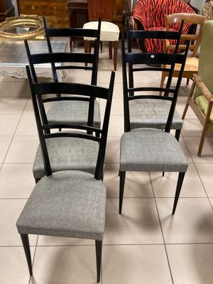 quatre chaises sont alignées en rangée sur un sol carrelé