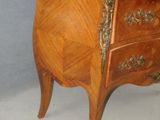 a small wooden chest of drawers with a marble top
