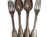 three silver spoons and a fork on a white surface