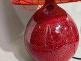 a red table lamp with a pink shade on it