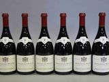 six bouteilles de vin sont alignées sur une table