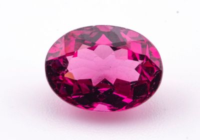 un gros plan d'un diamant rose sur une surface blanche