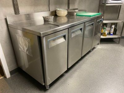 a stainless steel counter with bowls and plates on it