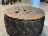 une table fabriquée à partir d'un pneu, posée à même le sol