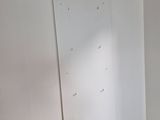 a small bed in the corner of a room with a white wall