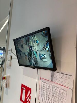 une télévision à écran plat fixée au mur au-dessus d'un extincteur