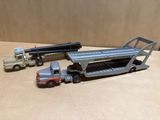 trois camions miniatures et un semi-remorque posés sur une table