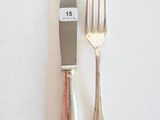 deux fourchettes et un couteau sur une table blanche