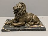statue of a lion on a marble base on a table