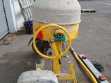 concrete mixer on a trailer in front of a building