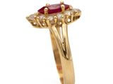 an image of a gold ring with a red stone surrounded by diamonds