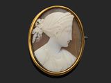 une broche en coquillage sculpté représentant le profil d'une femme