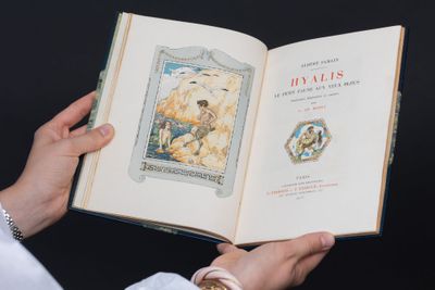 une personne tenant un livre ouvert sur lequel figure l'image d'un ours polaire