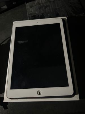 Un iPad est posé sur une boîte, sur une table.